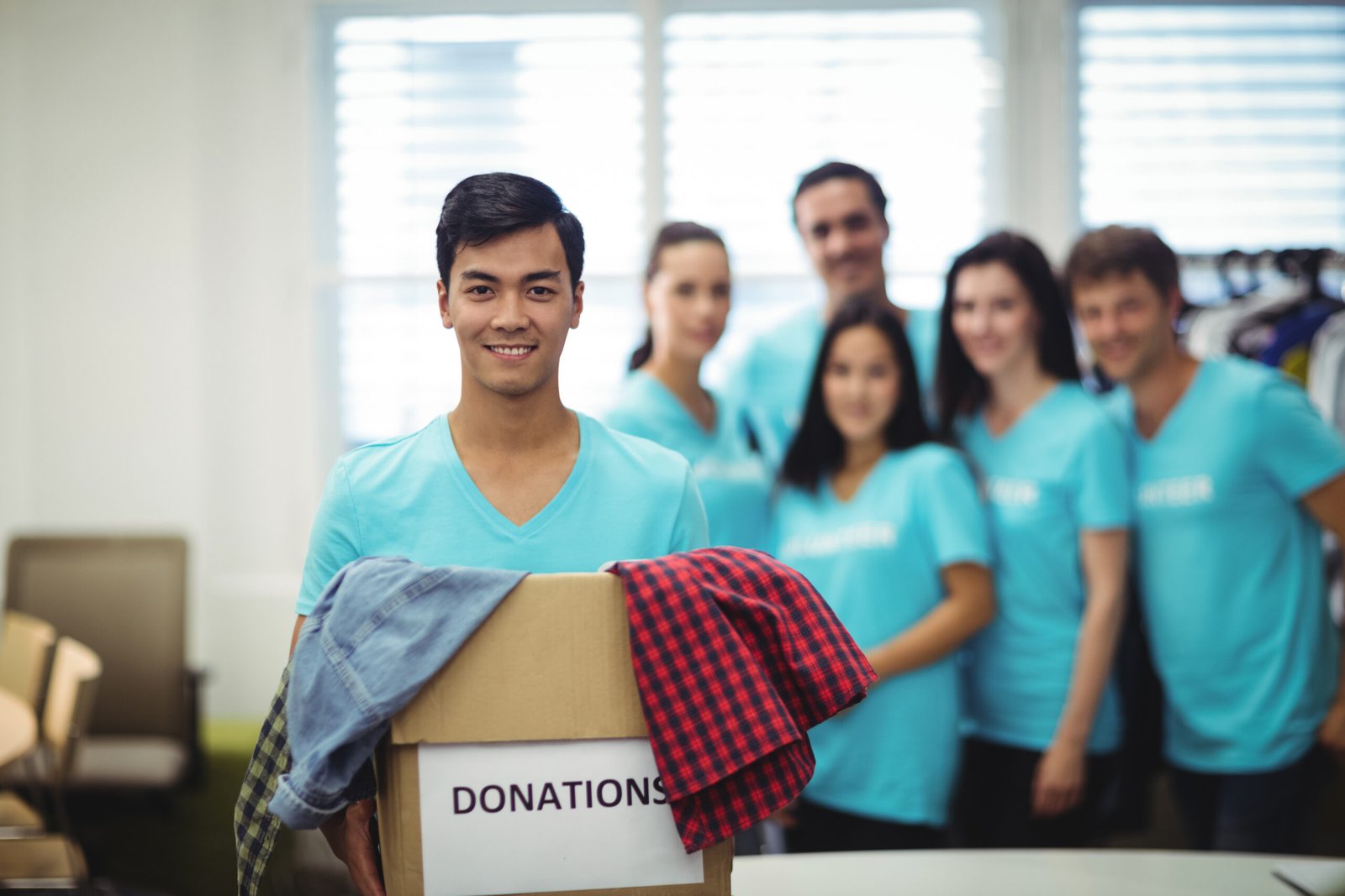 volunteer holding clothes donation box scaled